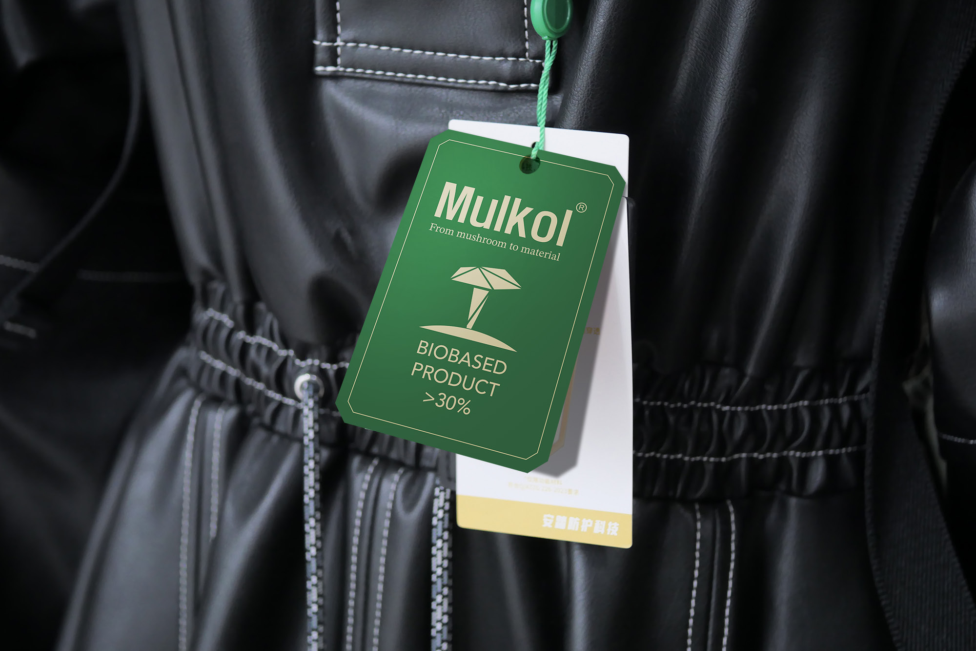 Green Mulkol biobased-content label attached to a black garment